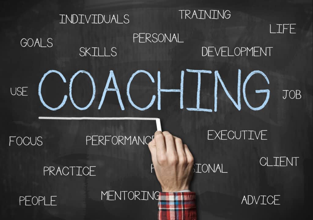 excellent business coach characteristics concept with coaching related words being written on a chalk board