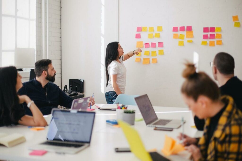 Employee performance concept with colleagues gathered around a conference room discussing business tactics