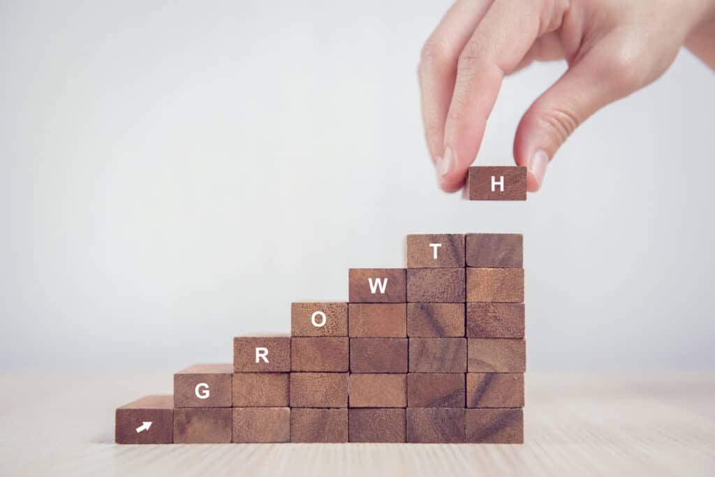 Close up Woman hand arranging wood block stacking as step stair. Business concept growth success process.