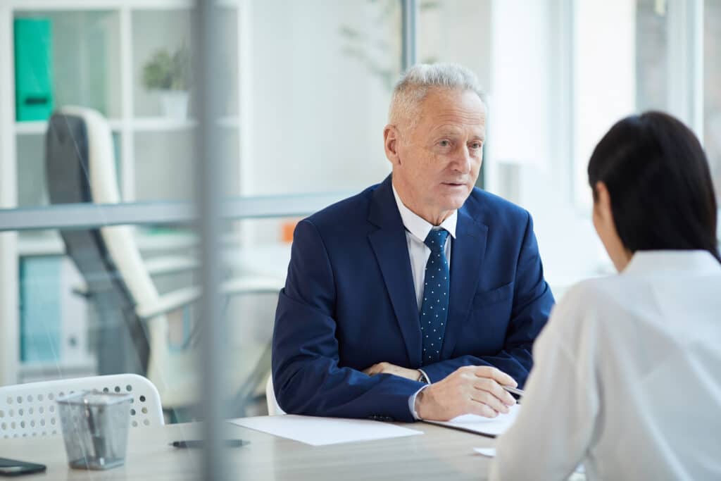 Portrait of successful senior businessman discussing his succession planning strategy with his young daughter who is an employee of his