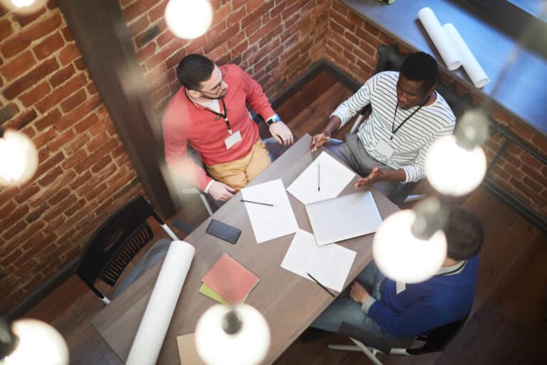 Men discussing the points of a startup business plan around a conference table